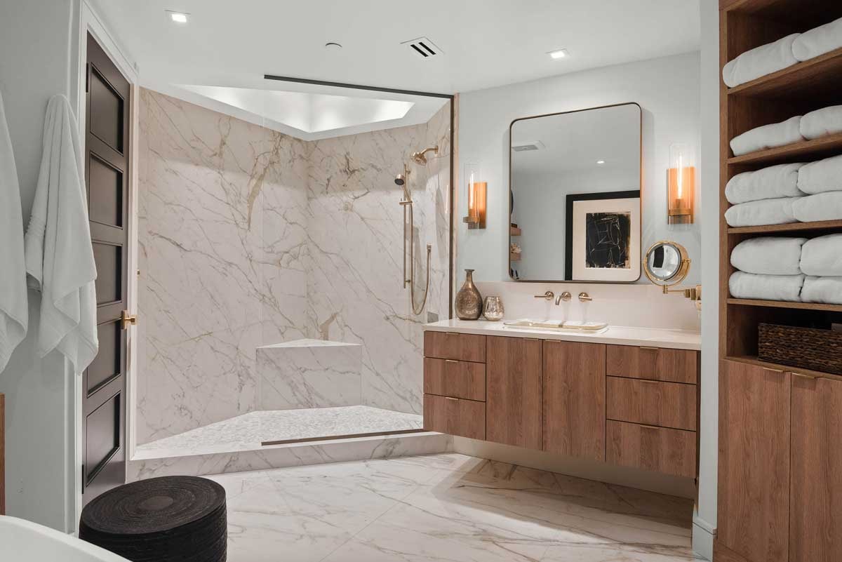 A modern minimalist master bathroom with a floating vanity and individual sinks.